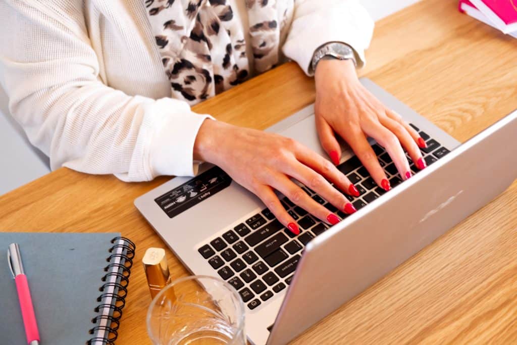 Vrouw typt op laptop aan bureau